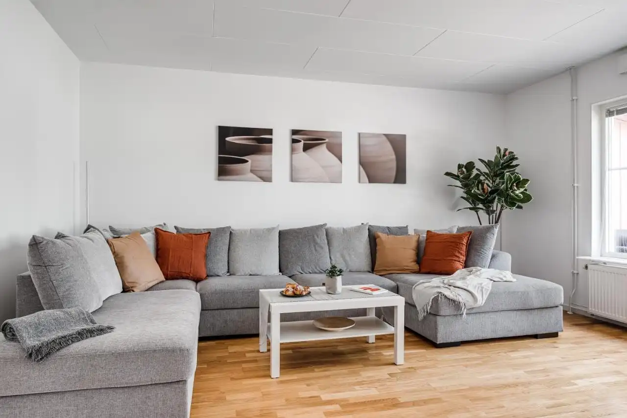 Modern living room with large grey sofa in Uppsala house for rent