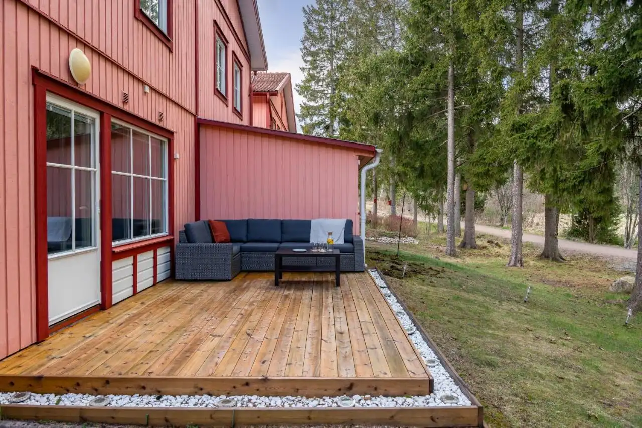 Large wooden deck with outdoor sofa at Uppsala short term rental
