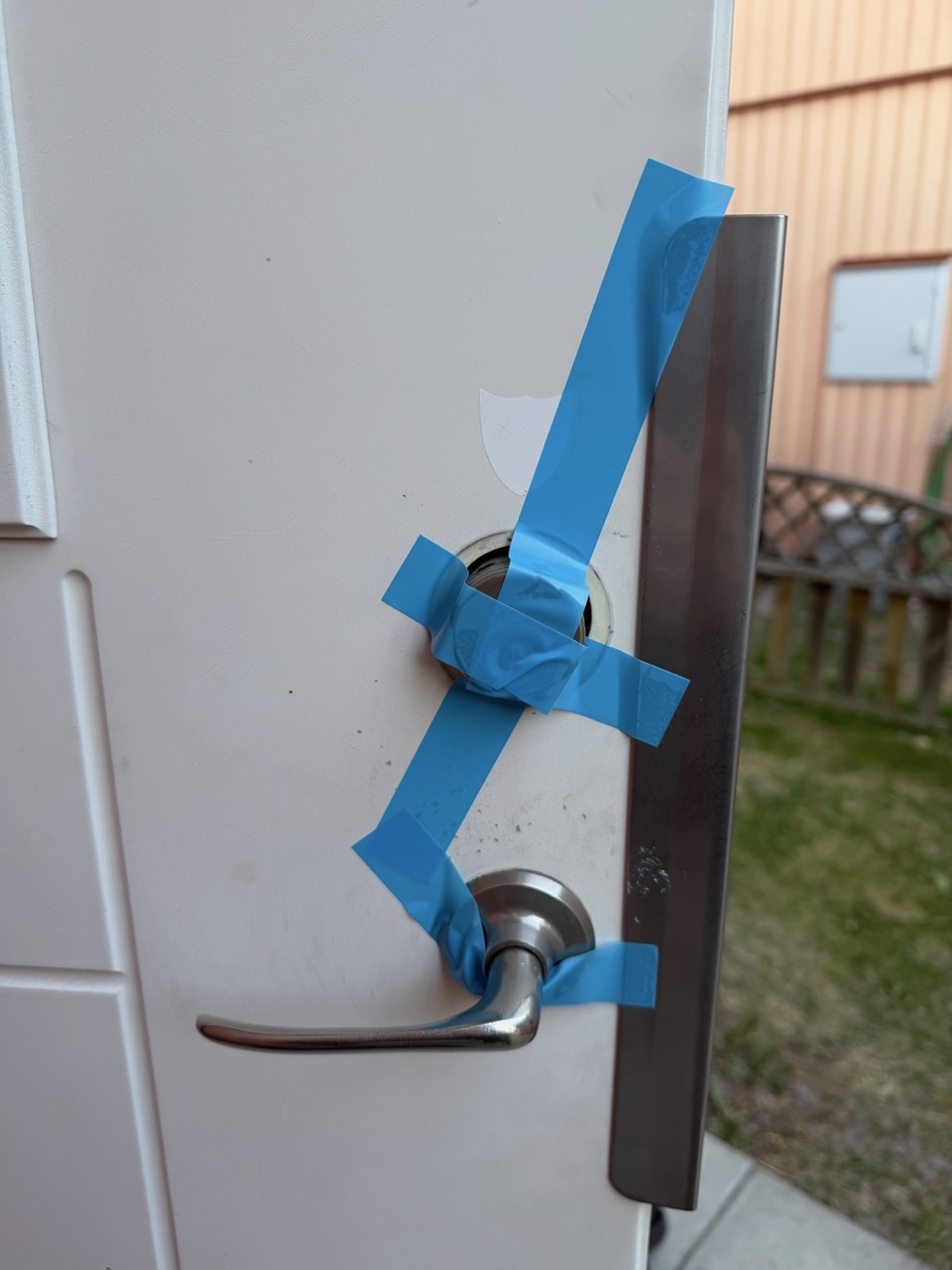 Front door exterior held in place with blue painter's tape during install