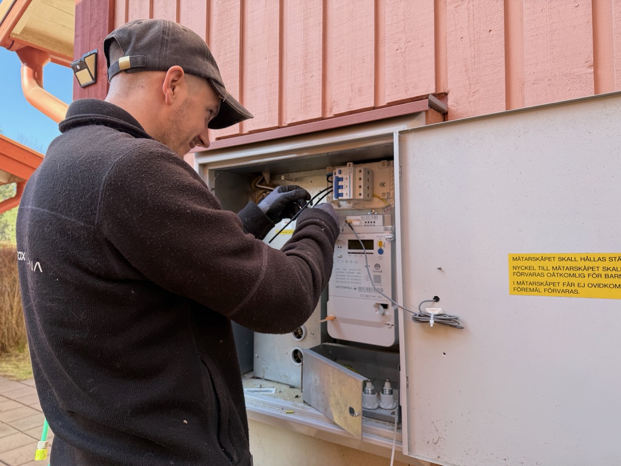 Close-up of Magnus working inside the fuse box with the meter visible