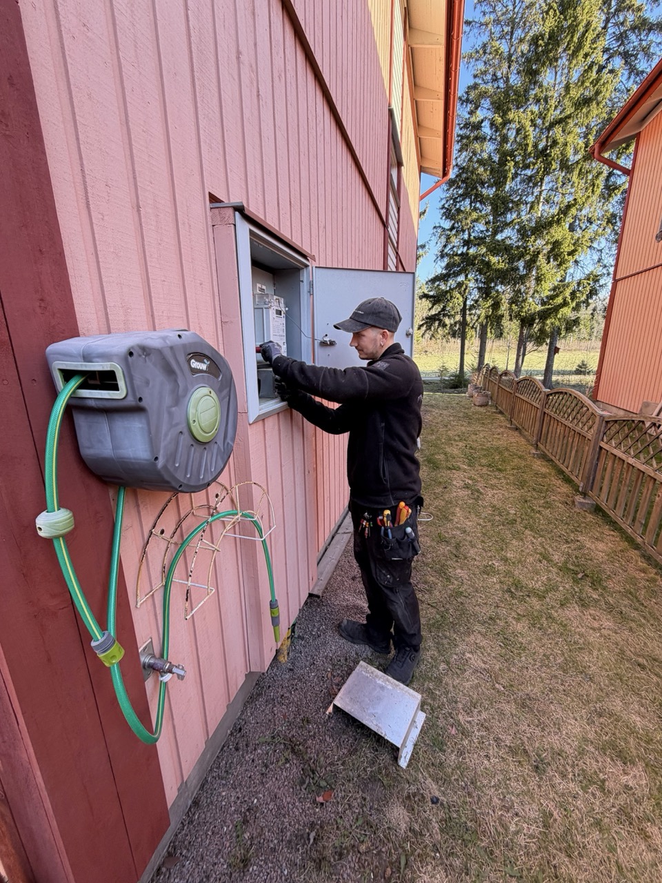 Magnus opening the fuse box with the side door swung wide
